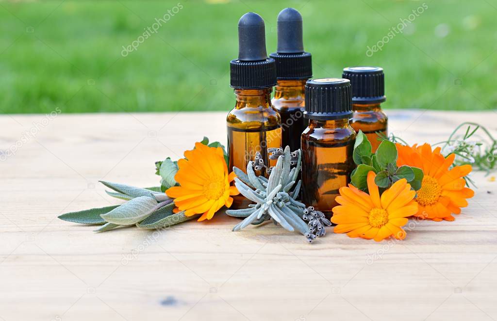 Set of brown bottles with essential and cosmetic oils, fresh herbs and flowers, aromatherapy, phytotherapy.