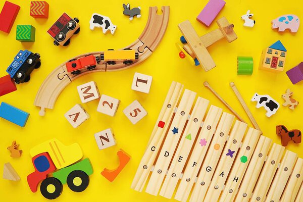 Деревянные красочные детские игрушки и музыкальные инструменты плоские лежали на желтом фоне, играть и учиться
.