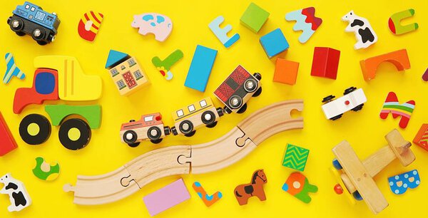 Красочный баннер с деревянными игрушками для детей на желтом фоне
.
