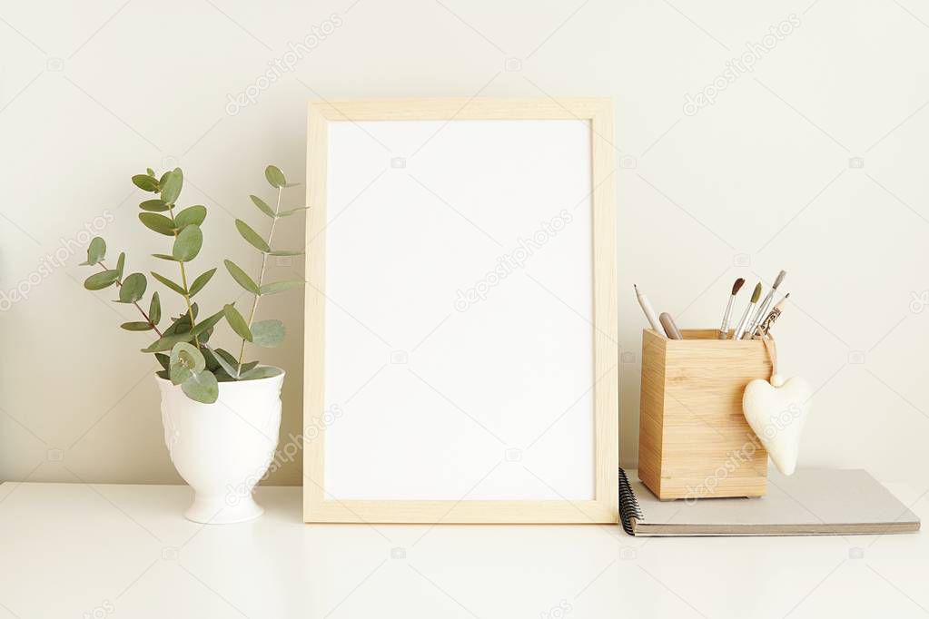 Minimalist interior empty frame mock up on white background, eucalyptus and wooden decoration.    