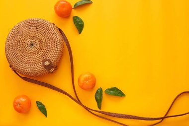 Sarı yaz arkaplanı, mandalina ve turuncu çanta, düz yatak, tatil, yaz modası konsepti.