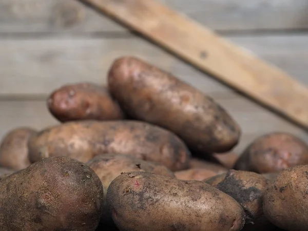 Kartoffeln auf einem hölzernen antiken Hintergrund. Eigener Hof. — Stockfoto