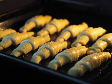 Fırında pişirmeye hazır, siyah bir tavada çiğ simit..