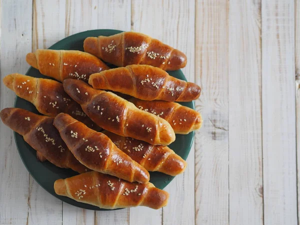 Fertiggeröstete hausgemachte Bagels auf einem schwarzen Backblech aus dem Ofen. Fertig zum Essen. Mit Sesam bestreut. Wohnküche. — Stockfoto