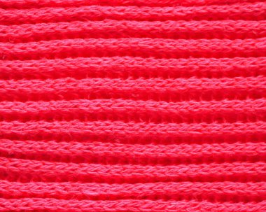 Örgü kumaş dokusu. Kırmızı renk. Ön ve arka halkalarla İngilizce örgü örüyor. Örgü iğnelerinin üzerine örgü örüyorum. Yatay çizgiler