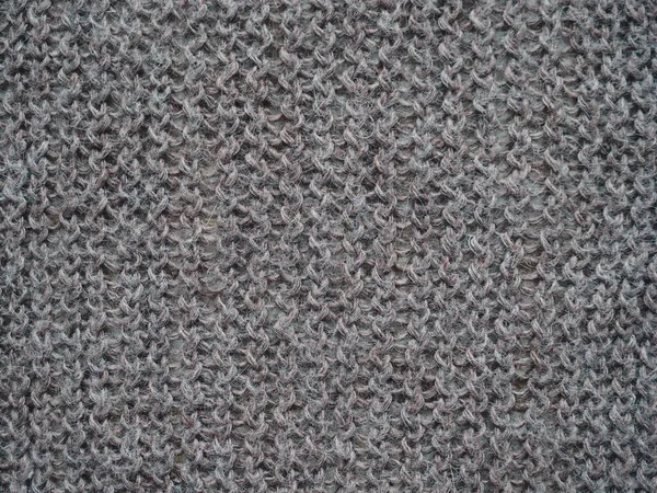 Knitted fabric texture. Gray. Simple knitting with front and back loops. Knitting on the knitting needles. Horizontal lines. — Stock Photo, Image