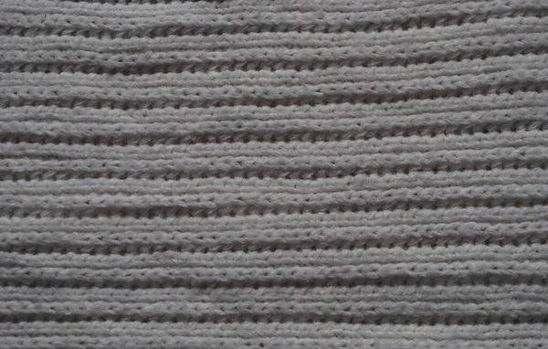 Textura de tecido de malha. Cinza. Tricô simples com laços dianteiros e traseiros. Tricô nas agulhas de tricô. Linhas horizontais . — Fotografia de Stock