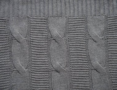 Örgü kumaş dokusu. Gri. Ön ve arka halkalarla basit örgü. Örgü iğnelerinin üzerine örgü örüyorum. Yatay çizgiler.