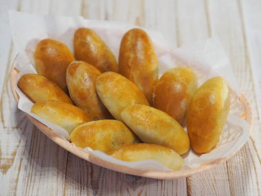 Yumurtalı ve yeşil soğanlı ev yapımı kekler. Tahta beyaz kırsal masa. Fırında pişirilmiş..