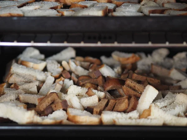 Cocina casera. Seque las migas de pan en el horno en una bandeja negra para hornear. Vegetariano. Ayuno cristiano . —  Fotos de Stock