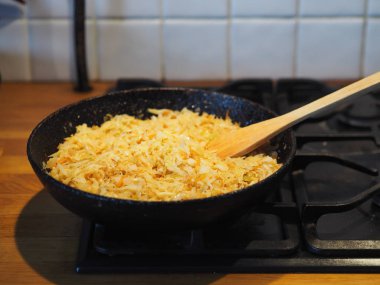 Ev yemeği. Ateşin üstünde siyah bir tavada kızarmış lahana. Turtayı lahana ile hazırlıyorum..