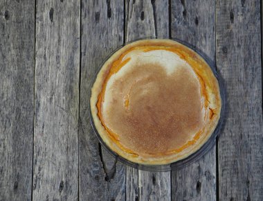 Yuvarlak ev yapımı balkabaklı turta, doğranmış ceviz, çırpılmış yumurtaya şeker. Ahşap kırsal arka plan. Ev yapımı pişirme..