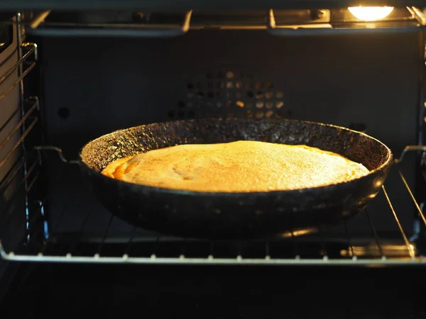 Στρογγυλή σπιτική πίτα με κολοκύθα, ψιλοκομμένα καρύδια, ολοκληρώνεται με χτυπημένα αυγά με ζάχαρη σε ένα τηγάνι στο φούρνο για ψήσιμο. Σπιτικό ψήσιμο. — Φωτογραφία Αρχείου