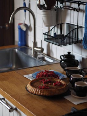 Elmalı ve üzümlü ev yapımı turtayı aç. Köy mutfağı. Ahşap tezgahta mavi kahve servisi. Kırsal mutfak..