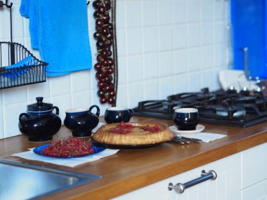 Elmalı ve üzümlü ev yapımı turtayı aç. Köy mutfağı. Ahşap tezgahta mavi kahve servisi. Kırsal mutfak..