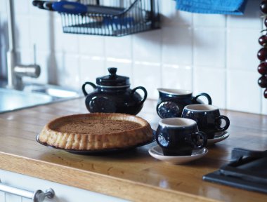 Elmalı ve üzümlü ev yapımı turtayı aç. Köy mutfağı. Ahşap tezgahta mavi kahve servisi. Kırsal mutfak..