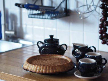 Elmalı ve üzümlü ev yapımı turtayı aç. Köy mutfağı. Ahşap tezgahta mavi kahve servisi. Kırsal mutfak..