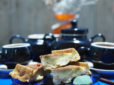 Elmalı ve üzümlü ev yapımı turtayı aç. Köy mutfağı. Ahşap tezgahta mavi kahve servisi. Kırsal mutfak..