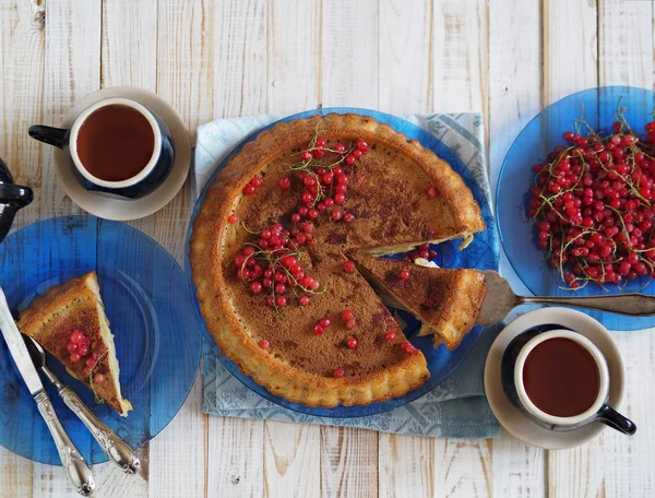 Pastel casero abierto con manzanas y grosellas rojas. Cocina rústica. Servicio de café azul en una encimera de madera. Cocina rústica . — Foto de Stock