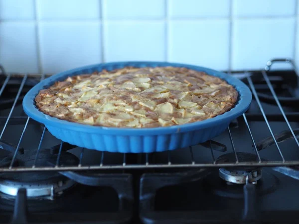 Eine offene hausgemachte Torte mit Äpfeln und roten Johannisbeeren wird in einem schwarzen Ofen gekocht. Hausmannskost. — Stockfoto