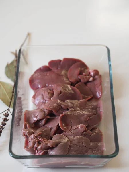 Rabbit liver on a glass baking sheet. We cut the rabbit into pieces. Home cooking, cook at home.