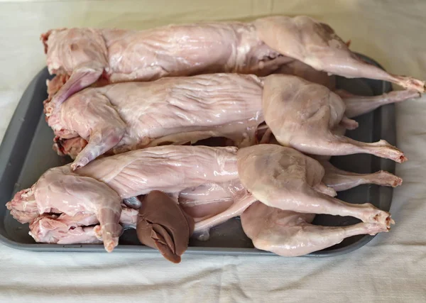 Carcasse de viande de lapin crue sur une plaque de cuisson en verre. Cuisine maison, cuisiner à la maison . — Photo