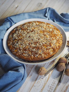 Ev yapımı pişirme. Yuvarlak elmalı turta ve ahşap beyaz bir kırsal masada mavi bir peçete..