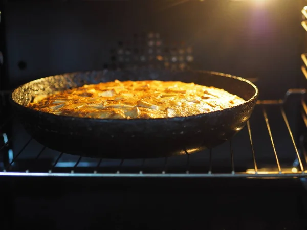 自制烘焙。 圆圆的苹果派放在烤箱的黑锅里. — 图库照片