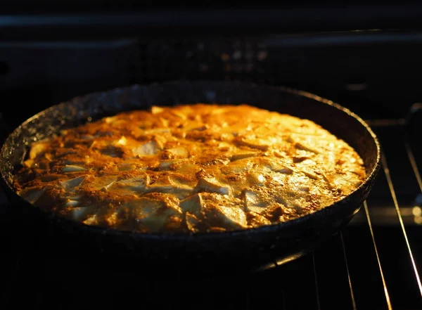 Hornear en casa. Tarta de manzana redonda en una sartén negra en el horno . —  Fotos de Stock