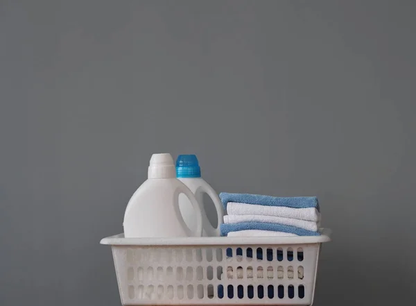 Plastikowe butelki do pakowania detergentu do prania odzieży z kolorowymi wieczkami w plastikowym koszu. Miejsce na tekst. Bio produkt organiczny. — Zdjęcie stockowe