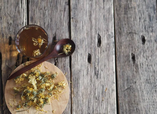 Сушені квіти календула і зварений лікувальний чай на дерев'яному старовинному столі. Збирання на зиму . — стокове фото