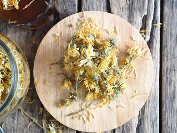 Flores secas caléndula y té medicinal elaborado en una antigua mesa de madera. Cosecha para el invierno . — Foto de Stock