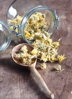 Kurumuş çiçek takvimi ve ahşap antik bir masada demlenmiş tıbbi çay. Kış için hasat..