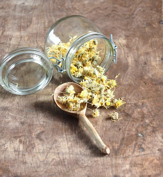Flores secas caléndula y té medicinal elaborado en una antigua mesa de madera. Cosecha para el invierno . — Foto de Stock