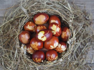 Paskalya. Paskalya soğanı kabuğu için yumurta boyamak. Geleneksel doğal renklendirme yöntemi. Tahta bir arka planda kamışla elek içindeki yumurtalar.