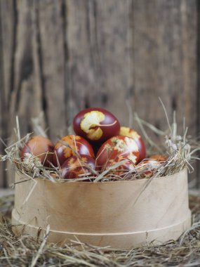 Paskalya. Paskalya soğanı kabuğu için yumurta boyamak. Geleneksel doğal renklendirme yöntemi. Tahta bir arka planda kamışla elek içindeki yumurtalar.