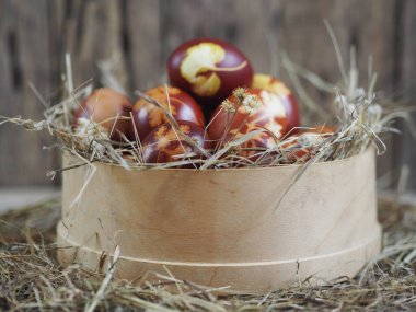Paskalya. Paskalya soğanı kabuğu için yumurta boyamak. Geleneksel doğal renklendirme yöntemi. Tahta bir arka planda kamışla elek içindeki yumurtalar.