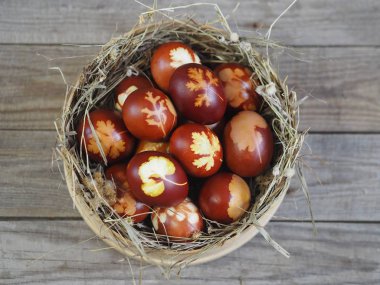 Paskalya. Paskalya soğanı kabuğu için yumurta boyamak. Geleneksel doğal renklendirme yöntemi. Tahta bir arka planda kamışla elek içindeki yumurtalar.