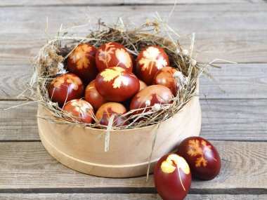 Paskalya. Paskalya soğanı kabuğu için yumurta boyamak. Geleneksel doğal renklendirme yöntemi. Tahta bir arka planda kamışla elek içindeki yumurtalar.