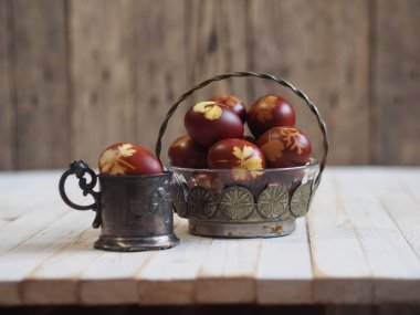 Paskalya. Paskalya soğanı kabuğu için yumurta boyamak. Geleneksel doğal renklendirme yöntemi. Ahşap arka planda yumurtalar. Metal vazo.