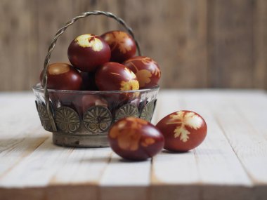 Paskalya. Paskalya soğanı kabuğu için yumurta boyamak. Geleneksel doğal renklendirme yöntemi. Ahşap arka planda yumurtalar. Metal vazo.