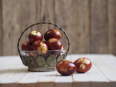 Paskalya. Paskalya soğanı kabuğu için yumurta boyamak. Geleneksel doğal renklendirme yöntemi. Ahşap arka planda yumurtalar. Metal vazo.
