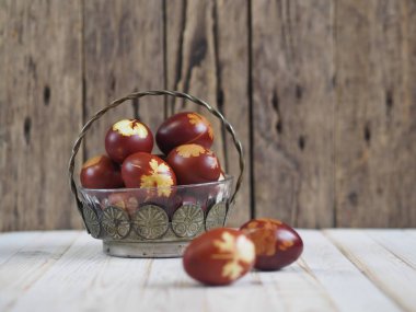 Paskalya. Paskalya soğanı kabuğu için yumurta boyamak. Geleneksel doğal renklendirme yöntemi. Ahşap arka planda yumurtalar. Metal vazo.