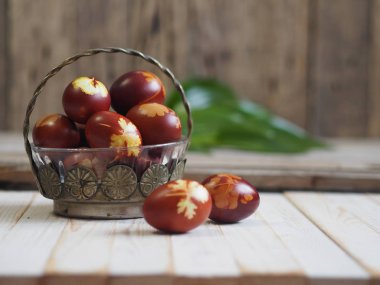 Paskalya. Paskalya soğanı kabuğu için yumurta boyamak. Geleneksel doğal renklendirme yöntemi. Ahşap arka planda yumurtalar. Metal vazo.