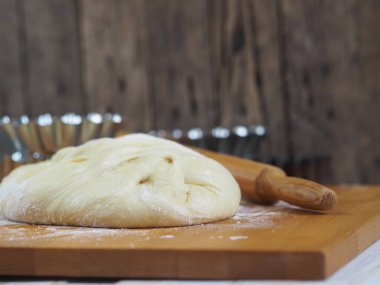Evde paskalya pastası pişiriyorum. Paskalya pastaları için taze hamur işi. Kurabiye keskisi ve ahşap arka planda..