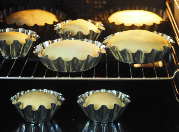 Cozinhar bolos de Páscoa em casa. Pastelaria fresca para bolos de Páscoa com cortadores de biscoitos em um fundo antigo de madeira . — Fotografia de Stock