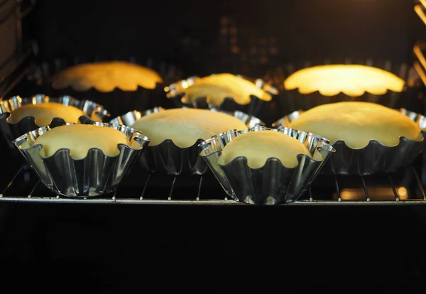 Cozinhar bolos de Páscoa em casa. Pastelaria fresca para bolos de Páscoa com cortadores de biscoitos em um fundo antigo de madeira . — Fotografia de Stock