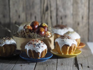 Paskalya. Evde paskalya pastası pişiriyorum. Eski ahşap bir arka planda doğal serpintiler ve renkli yumurtalarla Paskalya pişirme.