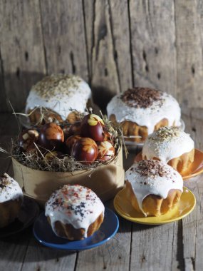 Paskalya. Evde paskalya pastası pişiriyorum. Eski ahşap bir arka planda doğal serpintiler ve renkli yumurtalarla Paskalya pişirme.