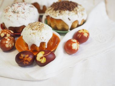 Paskalya. Geleneksel Paskalya pastaları ve doğal bir masa örtüsü üzerine soyulmuş soğan yumurtaları. Ahşap antik arka plan. Tatili kutluyoruz. Doğal malzemelerle serpiştirilmiş..